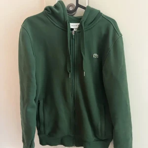 Lacoste zip Hoodie - En Lacoste zip hoodie i storlek S.  Skick 8/10.  Rökfri, bra kvalite och välskött.  Sällan använd.  