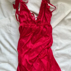 Lång mörkrosa klänning - Lång mörkrosa klänning med svarta prickar. Ett band på ena sidan (andra bilden) har lossnat, men går att sy fast.