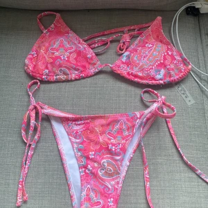 Rosa mönstrad bikini - Helt ny bikini. Rosa med mönster. Jättefin på. Endast provad (med cykel byxor och bh) pads i 