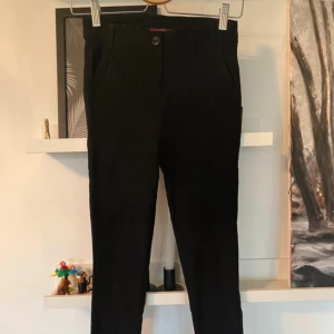 Byxor - Svarta byxor, lite konstymliknande, en del strech  Storlek Xs