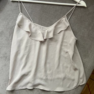 Topp med volang  - Grå söt top från Ginatricot med volang. Nyskick, den första bilden gör sig färgen rätt på! Stl S 