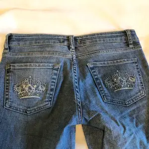 Jättefina jeans med kronor på bakfickorna och rhinestones. Dom är bootcut! Jättebra skick! Midjemåttet är 72cm och innerbenslängden är 82cm💕 tryck på köp nu 💕