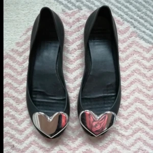 Coola ballerina skor - Svarta ballerinaskor med metallic hjärta på. Säljer då den är lite små på mig. Använda enstaka gånger men i väldigt bra skick🥰