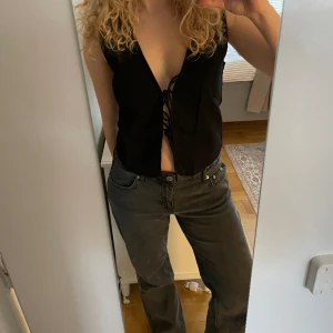 Svart väst - Så cool och trendig svart väst med snörning från Motel Rocks. Helt oanvänd med prislapp kvar!