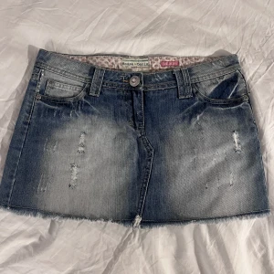 Cool jeanskjol med detaljer - Jeanskjol i fint skick med coola detaljer, midjemått: 40cm rakt över längd: 29cm Kolla gärna våra andra plagg