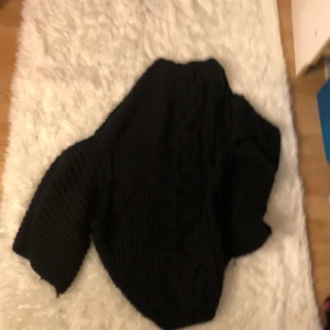 En stickad varm tröja  - En svart stickad kort ärmar 