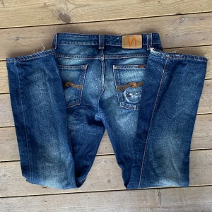 Nudie Jeans - Så snygga jeans från Nudie! De har en liten slitning på ena bakfickan och i benslutet men i övrigt fint skick ⭐️jag är 166 cm och de går ner till marken på mig. Midjemått: 41 cm. Innerbenslängd: 80 cm