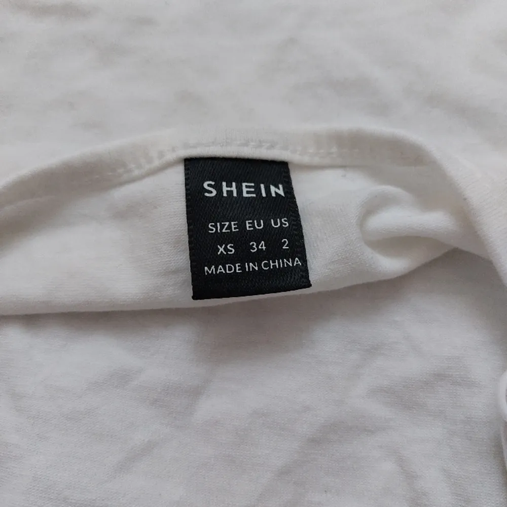 Ett kort vitt linne med korsade band från shein i stl XS. Använts ett fåtal gånger så nyskick. 20 kr+frakt🤍 skriv priv vid intresse eller frågor.. Toppar.