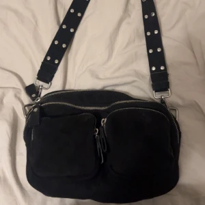 Svart väska - En perfekt liten väska där allt man behöver för dagen får plats i med gulliga detaljer! 