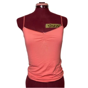 Korallfärgat linne - Supergulligt linne i korallfärg. Jätteskönt och följer kroppens former fint! Typ baddräkts liknande material.