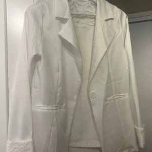 Vit kavaj - Vit kavaj med jättefina blommiga detaljer som passar storlek s/m. Oanvänd däremot ingen prislapp kvar