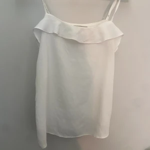 Vit linne - Säljer denna vita linnet med en liten volang upp till från H&M.