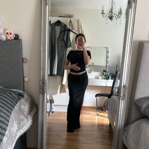 Trendig low Waist kjol med slits.  - Lång trendig low waist kjol med slits där bak. Fått den i present så vet inte riktigt vart den är ifrån men sitter mycket bra och har inga frakturer. Den är inte heller använd en enda gång då den är lite för lång på mig ( är väldigt kort ).