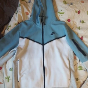 Baby Blue Nike Tech  - Storlek M är i bra skika inga defekter förutom lite sliten på dragkedja med den fungerar utan problem pris kan diskuteras 