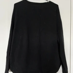 Ulltröja Wera M svart - Svart ulltröja från Wera i storlek M. Använd, men i god skick, och normalt slitage (lite nopprig). Rak modell med öppningar från båda sidorna  Material: 100% ull  Mått:  Längd ca 70 cm Byst ca 65 cm Midja ca 65 cm