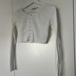 Vit topp - Vit croppad topp med knappar fram. Knappt använd. 