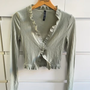 Kofta - Tunn kofta i grönt, stängs med 2 knappar. Kan även användas som tröja. Storlek XXS-XS