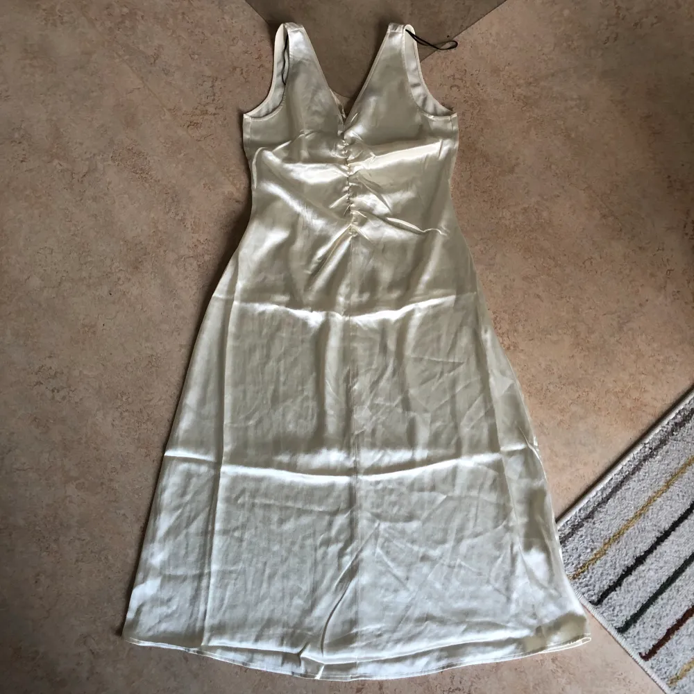 Superfin benvit klänning i silkesliknande material från H&M. Storlek M. Passar utmärkt till studenten. Aldrig använd, bara provad. Säljer för 80 kr. Köparen står för frakten 💕. Klänningar.