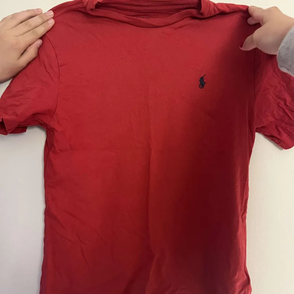 Säljer röd Ralph lauren t-shirt som är i nyskick och perfekt till sommaren! Storlek 150 men passar större. Nypris 399kr. T-shirts.
