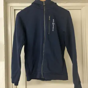 En riktigt snygg marinblå zip hoodie från sail racing. Den är storlek 170 och i mycket bra skick eftersom att den nästan är oanvänd. Orginalpris 999kr.