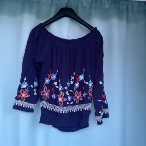 Tröja - Långärmad blå tröja med blommor på  Rynkkant både ner till och upp till 95% Bomull  5%Elastisk