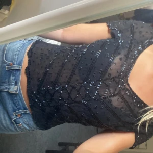 Svart topp med pärlor - Festlig genomskinlig svart topp med pärlor. Köpte i Polen så vet inte märket eller storlek. Men skulle säga att den är i s/m. Har använt den 1 gång så den är i bra skick!