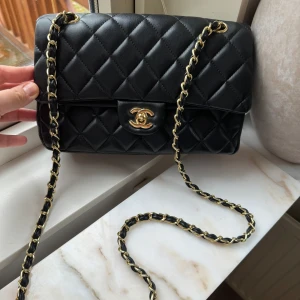 "Chanel" väska helt ny - Helt ny och oanvänd väska, fått den i present så vet ej om den är äkta. Höjd 16cm, längd 24 cm.