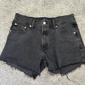 GAP jeansshorts (svarta) - Ett par svarta jeansshorts från gap, köpta förra sommaren i en gap butik i usa. Bara andvänd Max 3 gånger förra sommaren och nu säljer jag dom för dom är för små för mig. Hör av dig vid frågor ☺️