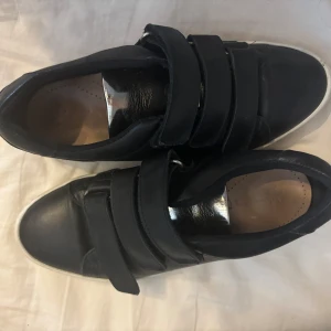 Trendiga sneakers - Väldigt bra skick, sparsamt använda sneakers med en snygg silvrig ” snörhållare”. Köpta för 400. Mycket stilrena och inga defekter alls. 