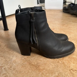 Boots med klack - Svarta boots med liten klack.  Använda några tillfälle, finns slitage  Se bilderna