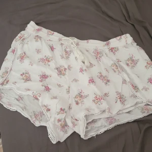 vita blommiga shorts i fint skick  - Jätte söta blommiga shorts  i fint skick knappt använt  perfekt till sommaren i bra kvalitet. :) 
