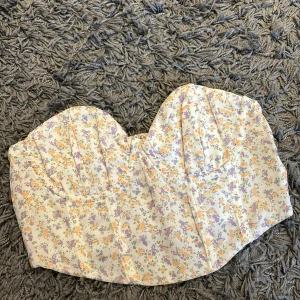 Korsett topp nakd  - Säljer min fina blommiga korsett topp från nakd. Den är aldrig använd utan endast testad. Säljer den då den var för liten.🥰Köptes för 299 men säljer den för 200!