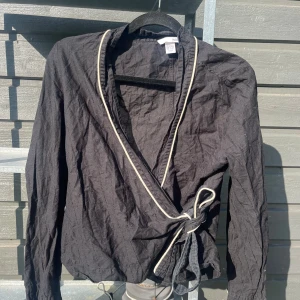 Svart blus med knytning - Svart blus med knytning och med små ränder i vit! Från hm 