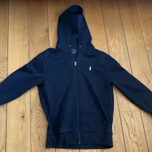 Blå Ralph Lauren zip hoodie i skick 9/10. Nypris är 2000+