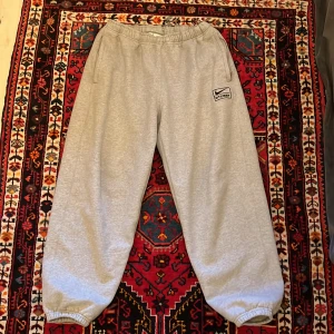 Stussy x Nike sweatpants - Otroligt snygga Stussy x Nike sweatpants i väldigt bra skick, gråa, baggy, storlek L
