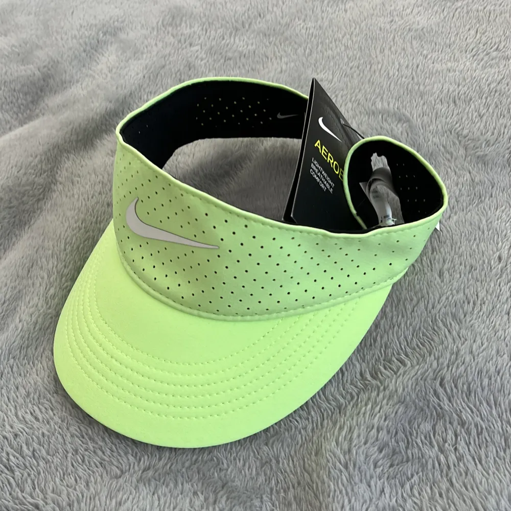 Halvkeps eller keps med öppen toppperfekt till tennis, padel eller golf. Helt oanvänd med lapp kvar. Neongrön från Nike. Accessoarer.