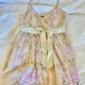 Jättegullig sommarklänning med rosor - Säljer då den tyvärr inte passar mig😭  Jättebra skick, perfekt för sommaren Jag är 170 cm och den går ner till knäna på mig. Klänningen har en dragkedja vid ena sidan🩷 (Två sista bilderna är lånade)