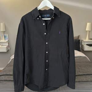 En svart polo ralph lauren skjorta i felfritt skick! Slim fit M, perfekt inför sommaren. Säljes då den ej kommer till användning längre. Nypris runt 1700kr.