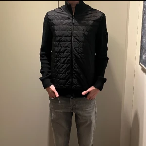 J.Lindeberg Cardigan - Säljer en riktigt fräsch J.Lindeberg cardigan i nyskick. Plagget är köpt i höstas och har inga skador. Nypris ca 3000kr. Har ni några funderingar är det bara att höra av er. 