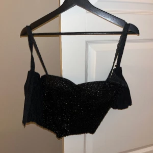 Korsett med paljetter framtill & spets baktill  - Dragkedja bak. 