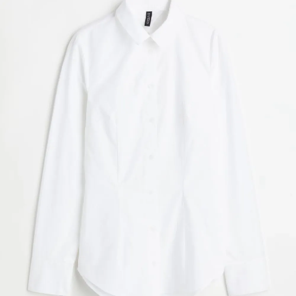 En vit skjorta från H&M med öppen rygg. Aldrig använd och prislapp finns fortfarande kvar.  Den sitter tight i midjan då det finns ett snöre man knyter i ryggen. Skjortor.