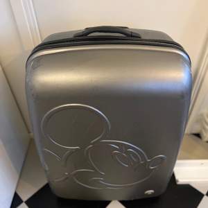 Superstor lätt grå resväska ca 32-50 kg / 120-140 liter ”Mickey Mouse” (Musse Pigg) Hjul och handtag fungerar perfekt.  75x55x 33 cm  OBS! Väger endast 4,4 kg trots att den rymmer jättemycket.  Liten spricka i plasten men funkar utmärkt. Inget kodlås