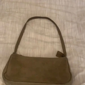 Brandy melville väska - Säljer denna sjukt snygga brandy melville väska, så cool och är så snygg. Säljer pga av brist av använding. Mocka och är såååå snygg. Köptes för 350 kr och säljs för 150 kr!!!! Passa på!❤️❤️‍🔥