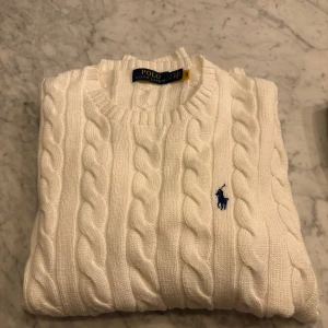 Polo ralph lauren tröja - Hej! Säljer nu min vita Polo ralph lauren stickade tröja size S (sitter som en större Small). Använts 1 gång på skolavslutning dvs inga skador och inga tecken på användning. Skick 10/10. Kvitto finns! Pris: 999kr (ny pris 1985kr)