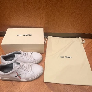Axel Arigato skor vita - Ett par snygga Axel Arigato skor i knappt använt skick, nypris ligger på 2700 kr. Låda samt dustbag ingår. Pris kan diskuteras.