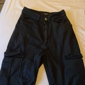 Jeans - Högmidjade cargojeans. Stolek 34 sitter väldigt tight i midjan. Resår vid fotleden  