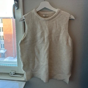 Väst - Jättefin stickad väst ifrån Nelly i en cremevit färg, endast använd ett fåtal gånger
