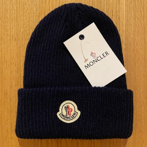 Moncler Mössa - Perfekt skick med plastpåse över samt tags, har 3 kvar i denna färg. Skriv privat för frågor! (Mörkblå)