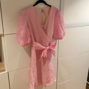 Rosa klänning - Så söt rosa klänning med puffärmar och band i midjan. Aldrig använt. Stl 38 men passar mig som har 36. 