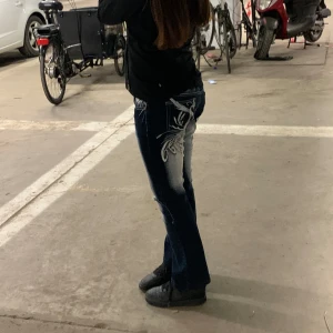 Blue queen jeans lowrise bootcut - Storlek 38 Midjan: 38cm Innersömm: 70cm  Hela längden: 90cm Två hål vid knäna de ena är mindre. Flesta paljetterna är av men ändra bra skick. Säljer eftersom dem va för korta för mig. Är 170cm